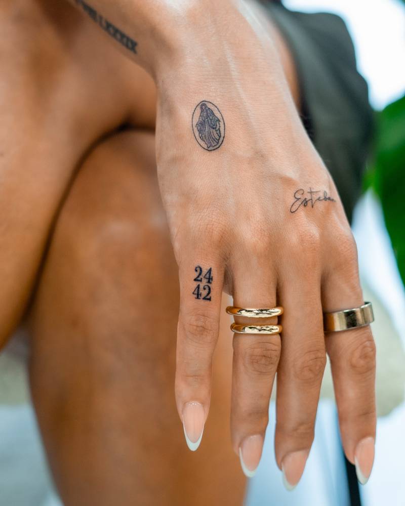 Numbers "24" and "42" tattooed on the finger.