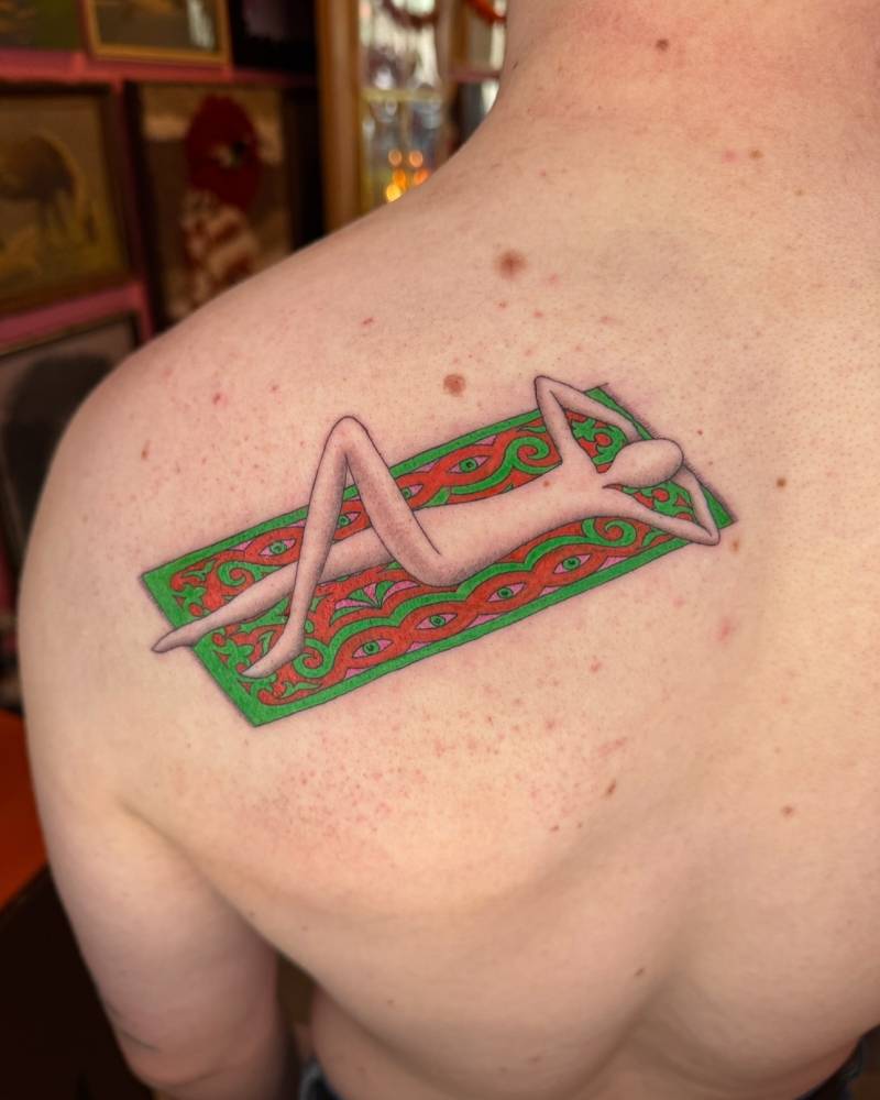 Sunbathing tattoo in illustrative style located on the shoulder blade.