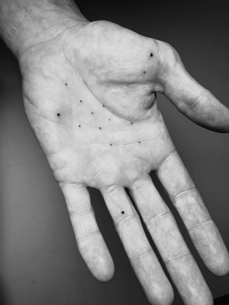 Constellation tattoo located on the palm of the hand.