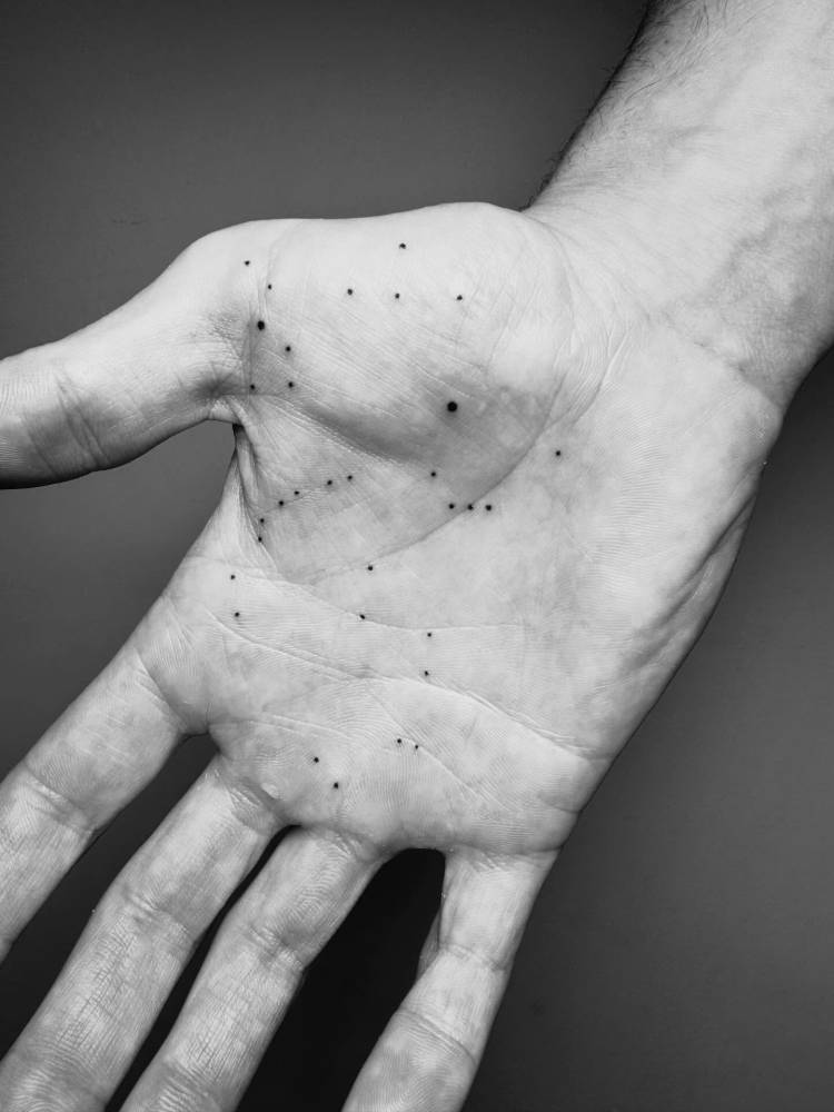 Constellation tattoo located on the palm of the hand.