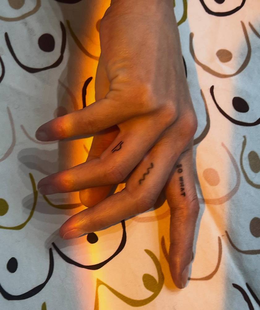 Tiny minimalist Libra zodiac symbol tattooed on the finger.