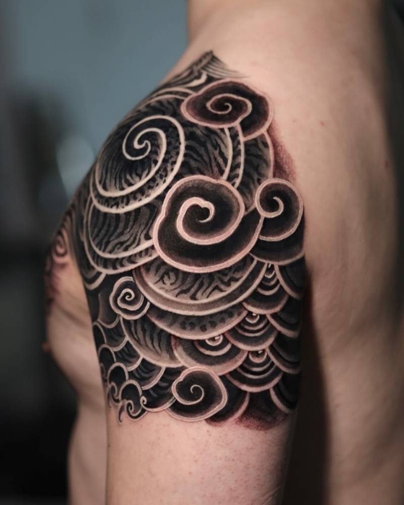 Oriental style cloud tattoo located on the shoulder.