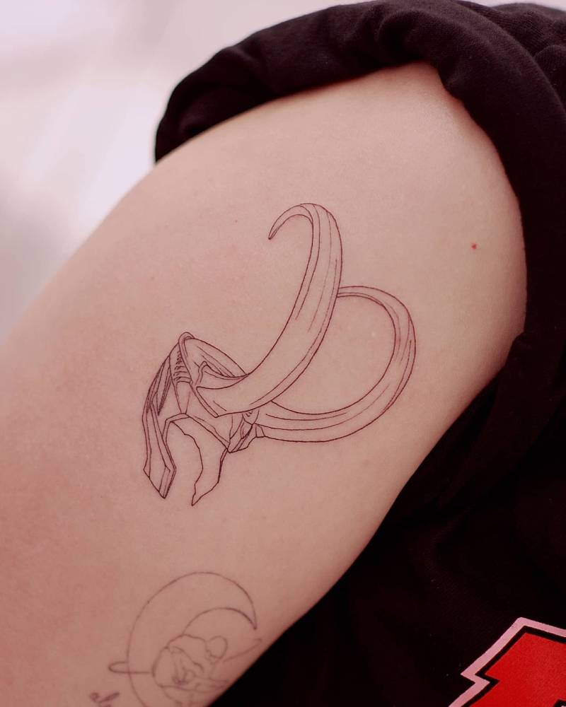 Loki helmet tattoo in fine line style located on the upper arm.