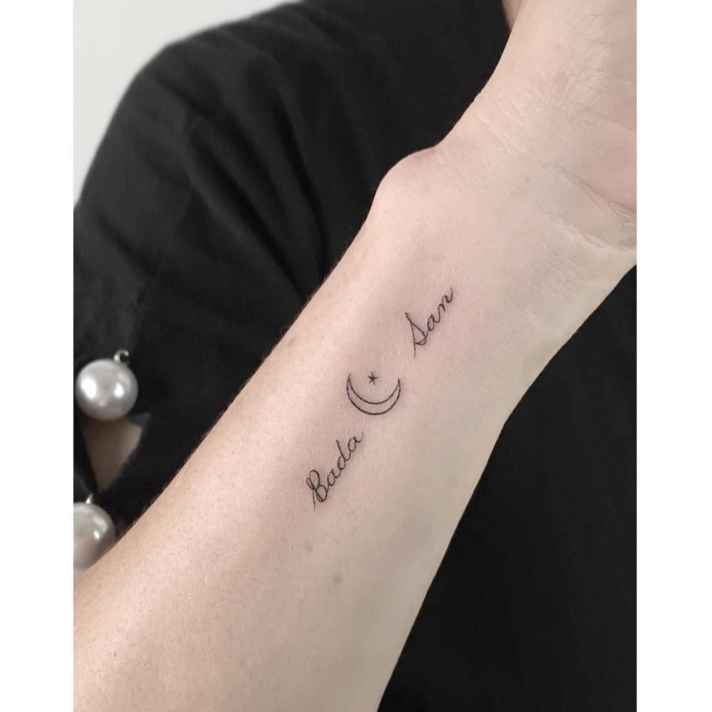 Names and crescent moon tattoo located on the wrist.
