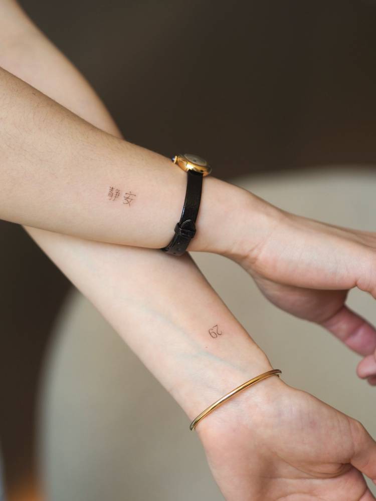 Chinese lettering and number "29" tattoos.