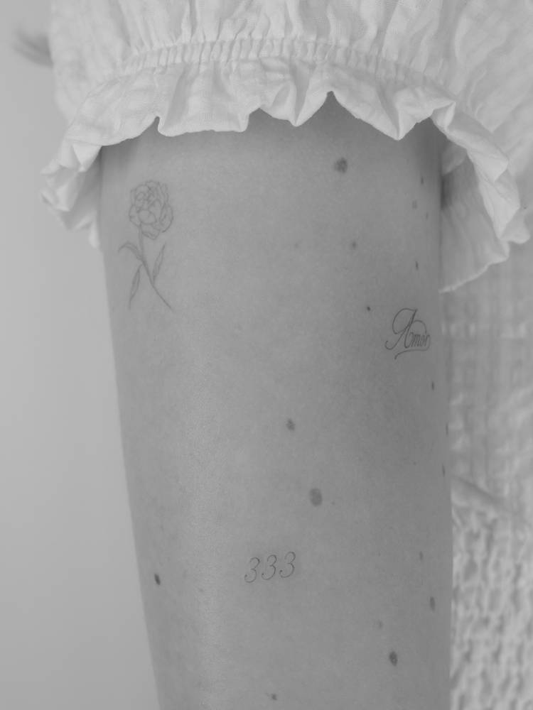 Angel number "333" tattoo located on the upper arm.