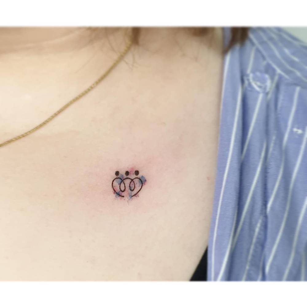 Abstract family symbol tattooed on the collarbone.