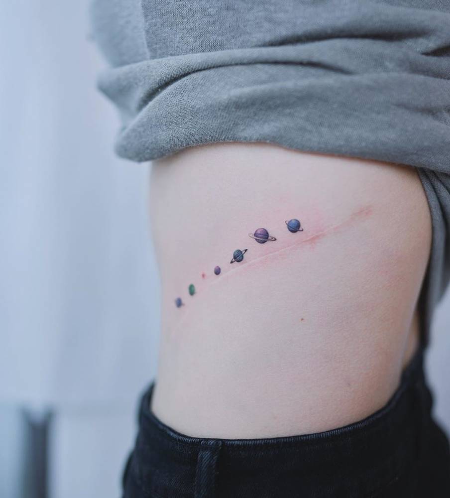 Small galaxy scar cover up tattoo located on the rib.
