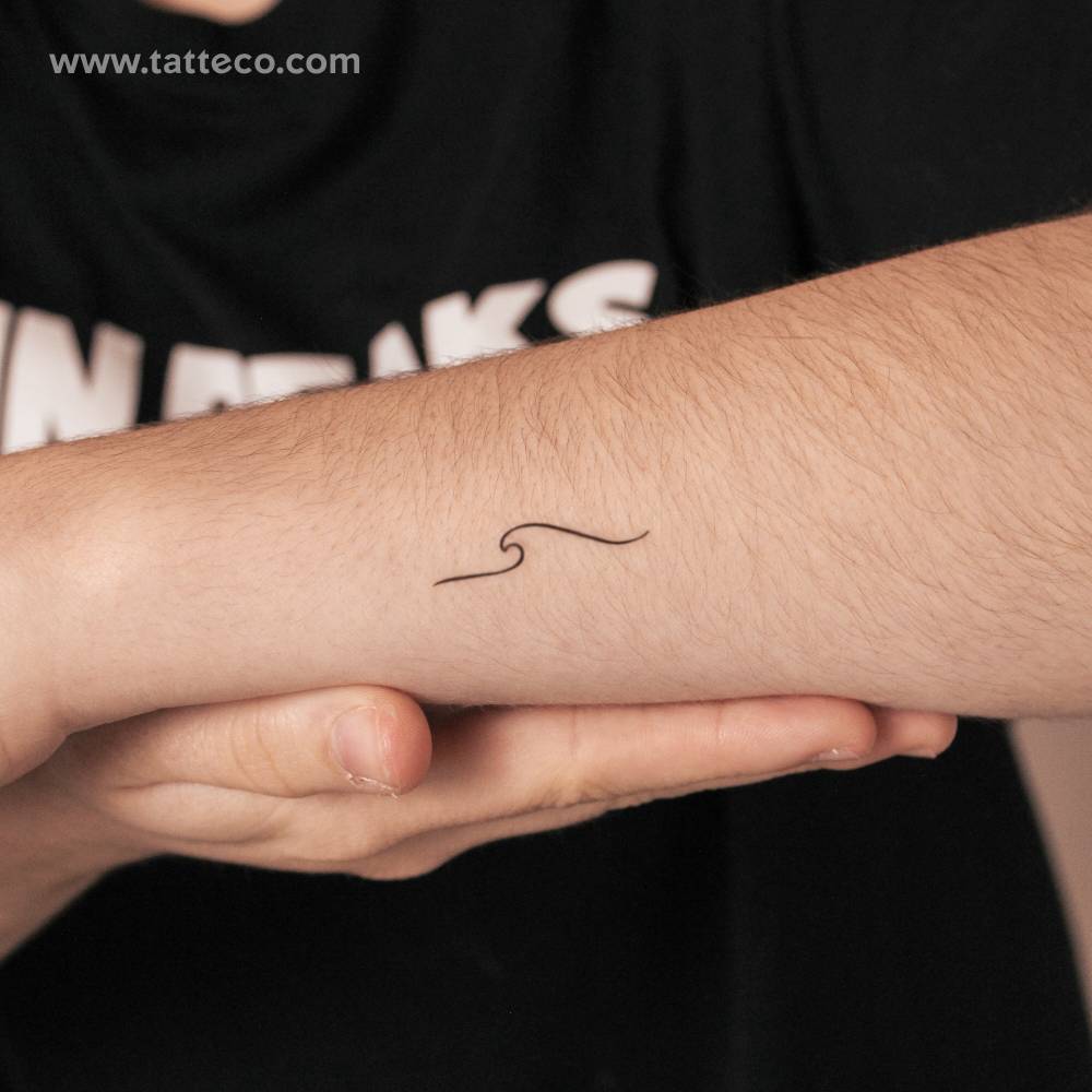Minimalist wave 2-week temporary tattoo located on the wrist.