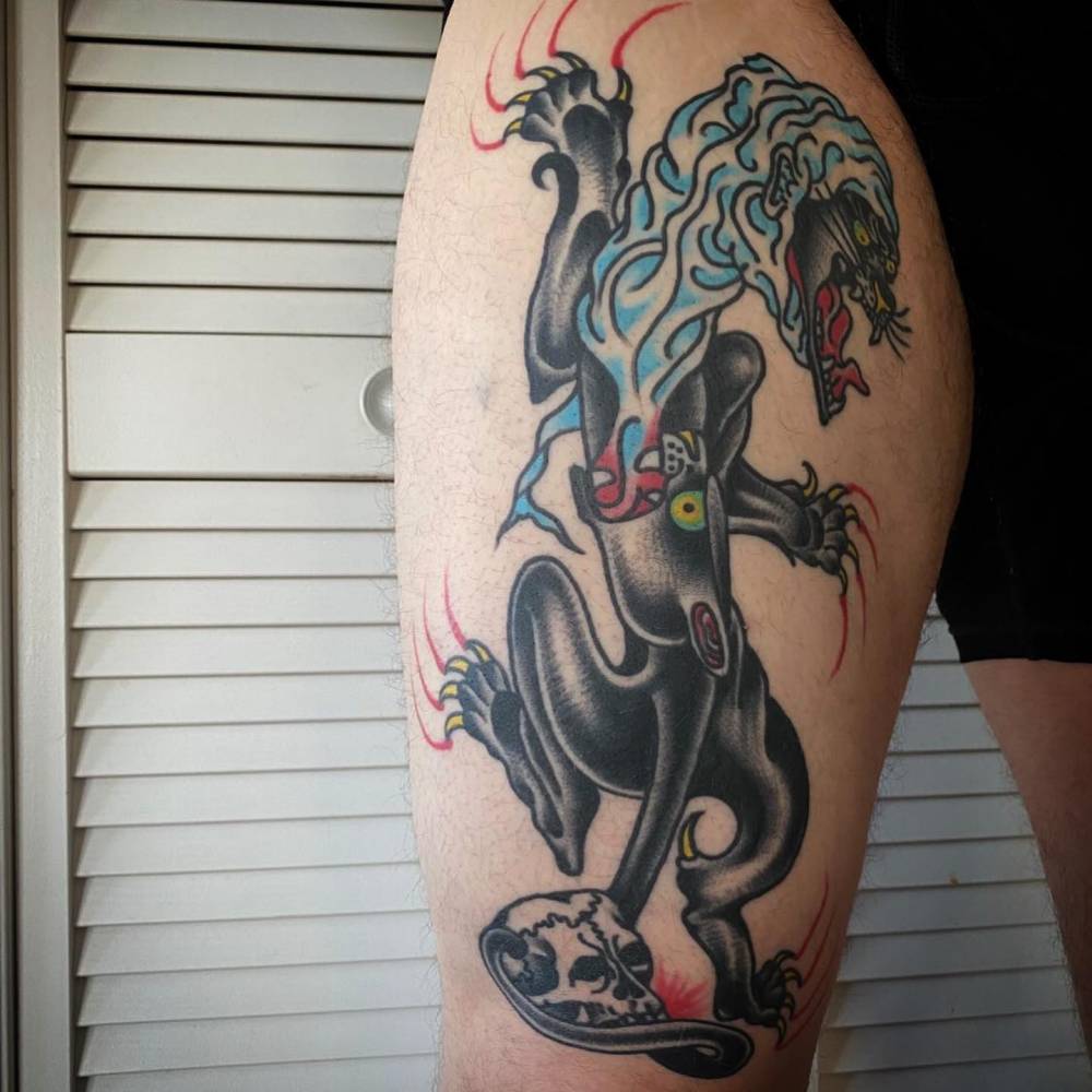 Healed panther tattoo in traditional style located on the thigh.