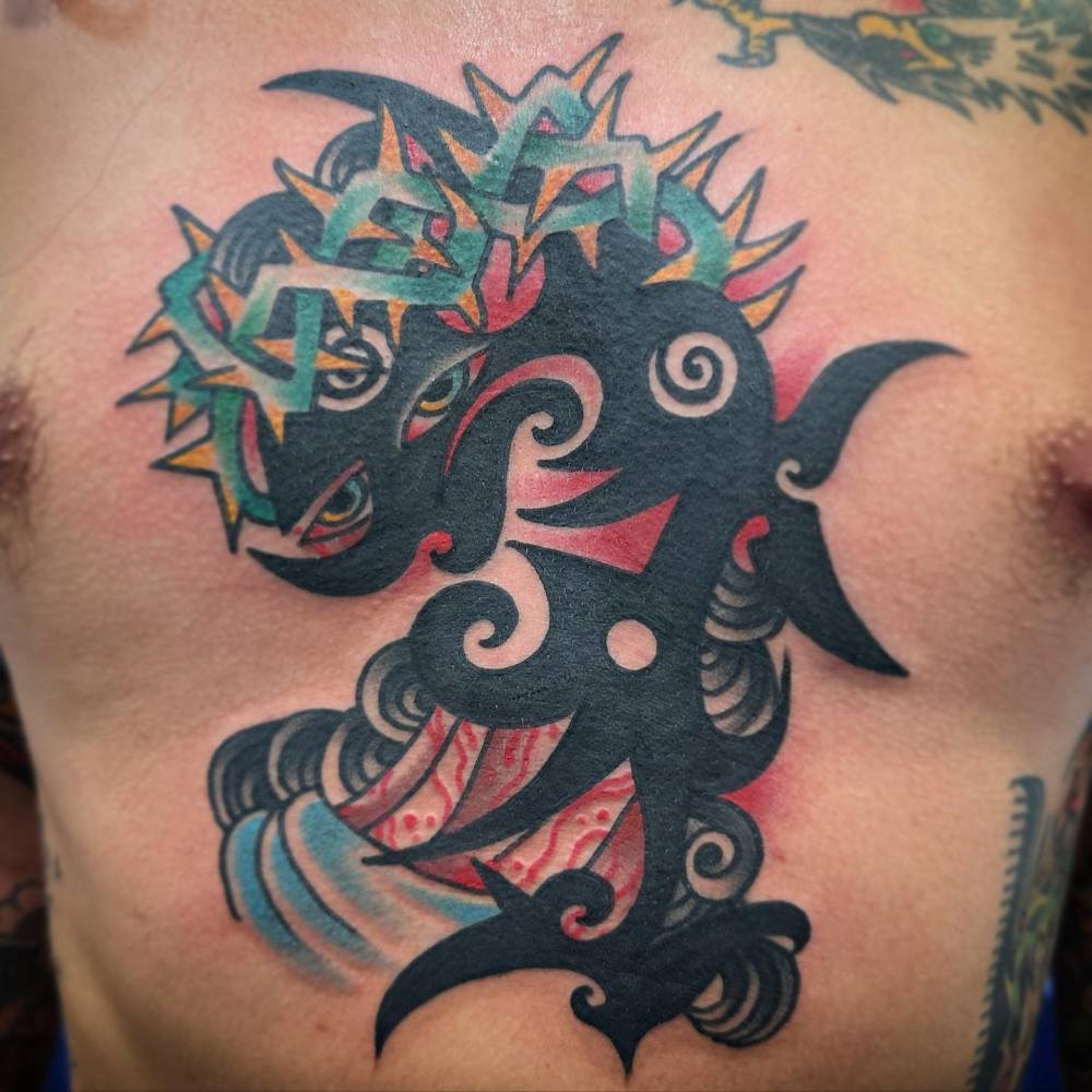 Abstract tribal Jesus tattoo located on the torso.