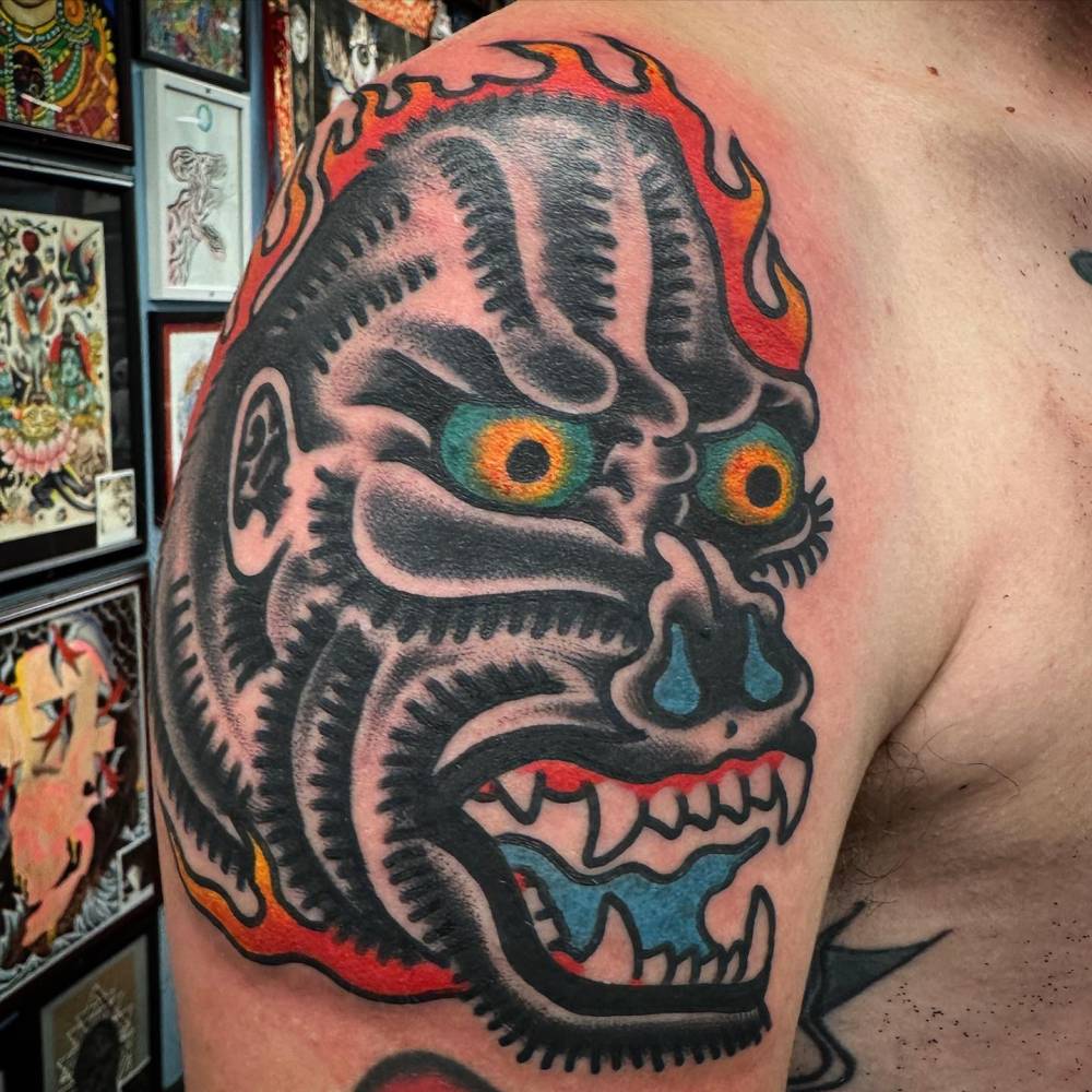 Gorilla portrait in traditional style tattooed on the shoulder.