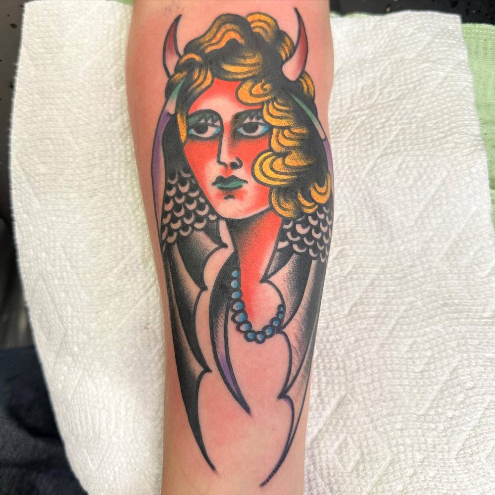 She Devil tattoo in traditional style located on the inner forearm.