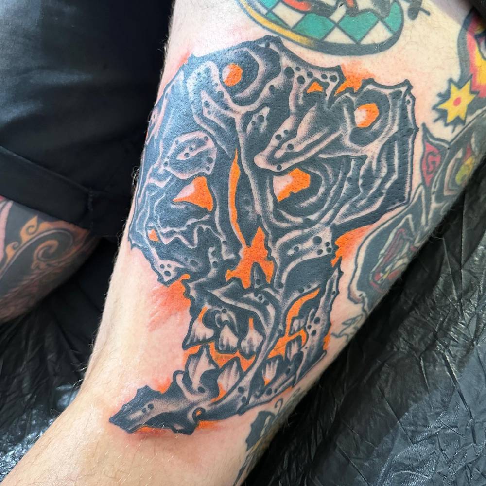 Skull tattoo in traditional style placed on the thigh.