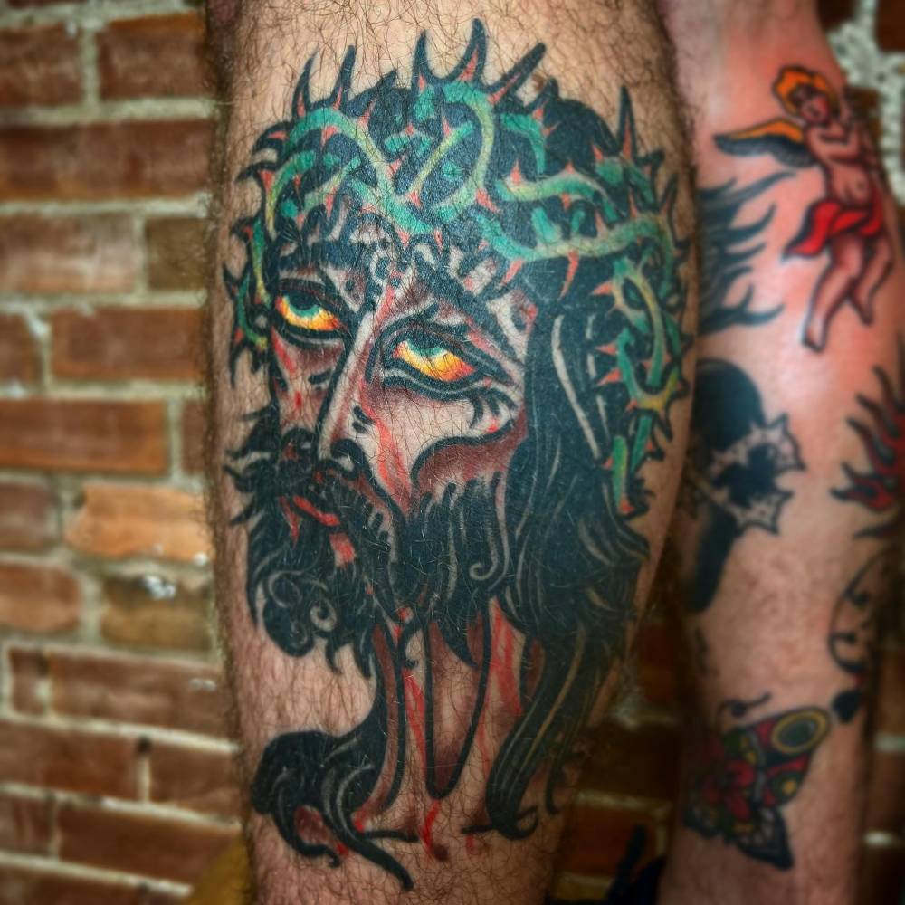 Healed traditional style JC tattoo located on the calf.