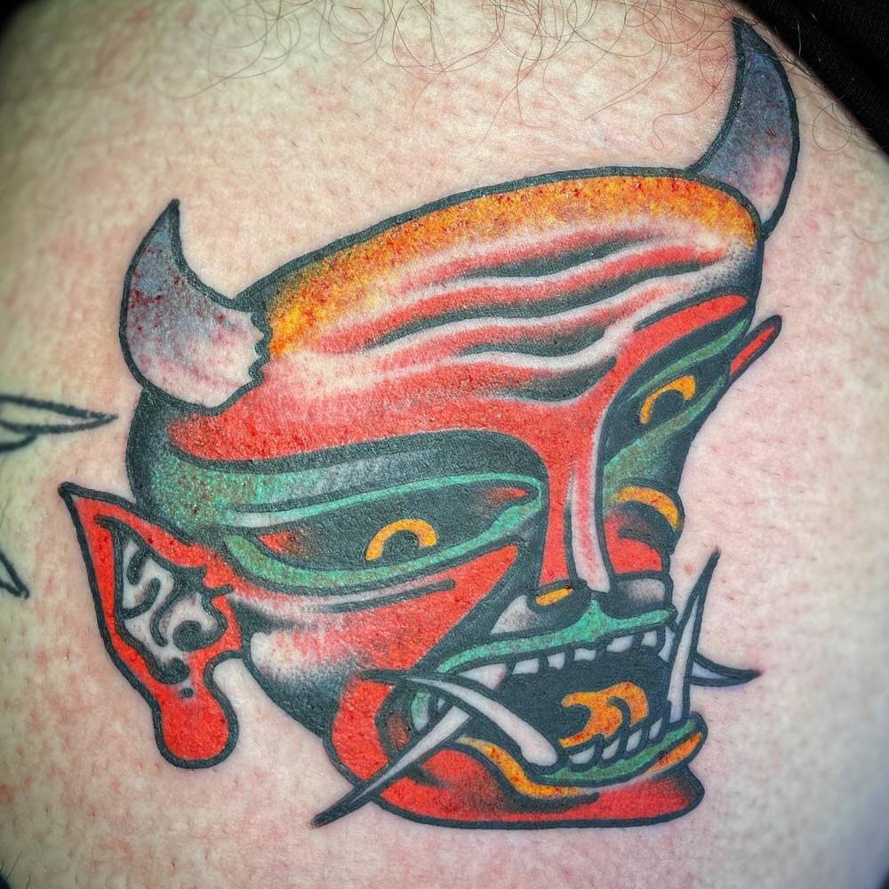 Devil tattoo in traditional style located on the thigh.