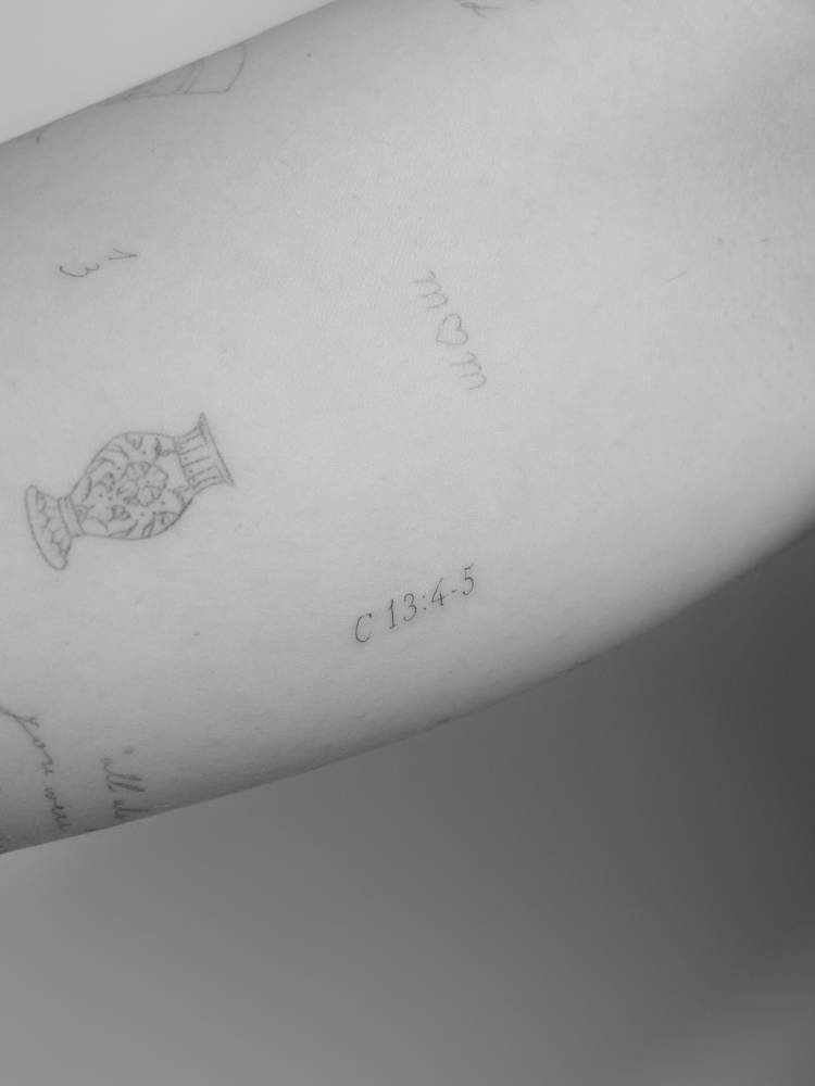 1 Corinthians 13:4-5 tattoo located on the inner forearm.