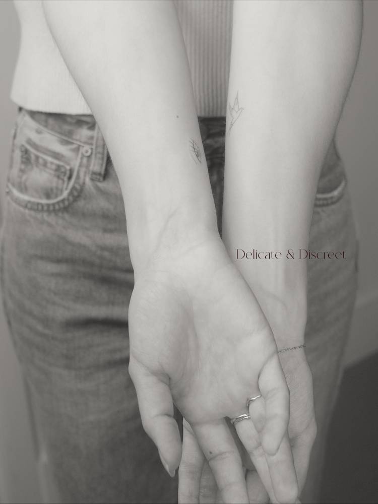 Tiny minimalist eye tattoo located on the wrist.