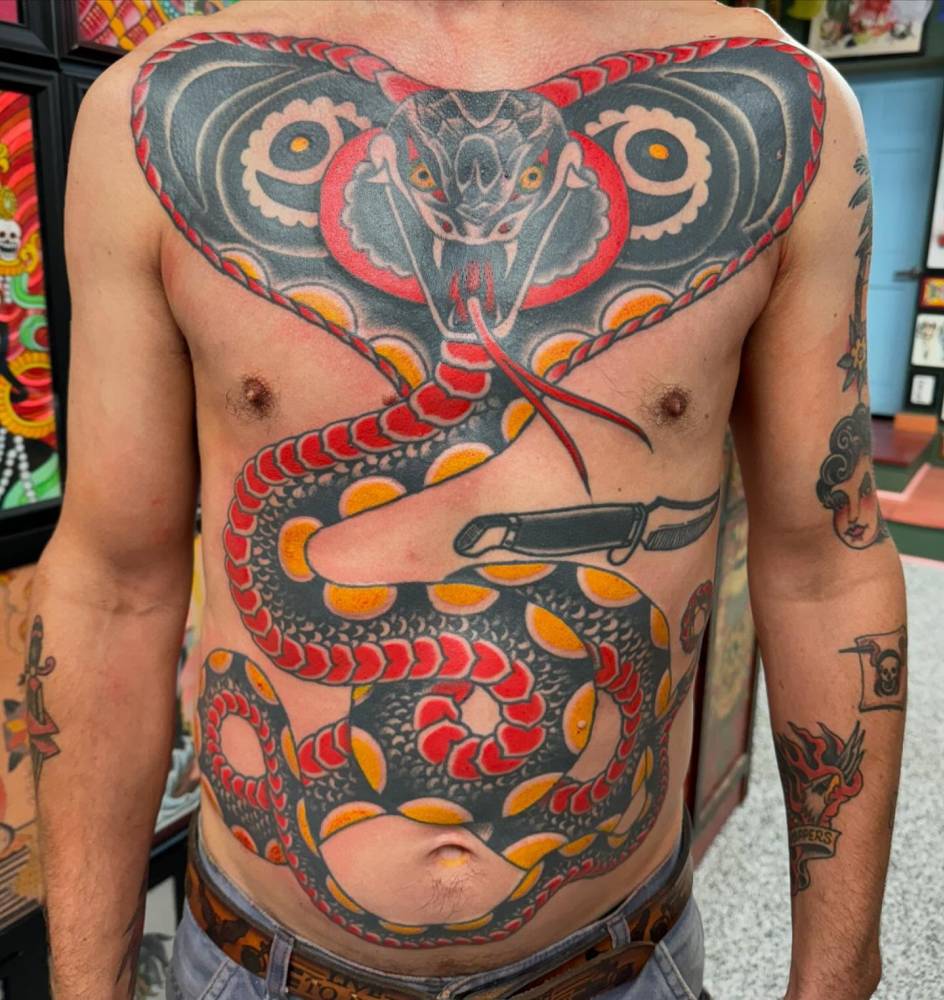 Traditional style king cobra tattoo located on the torso.