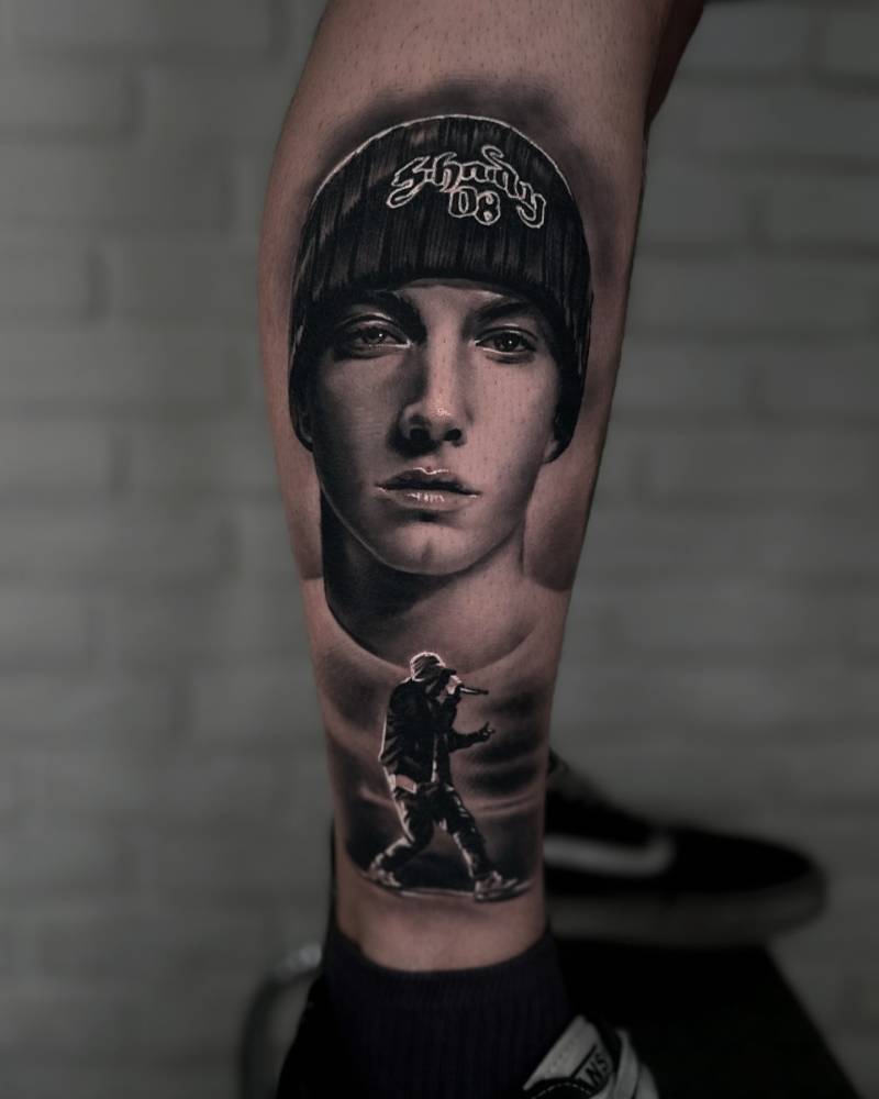 Eminem tattoo in black and gray style located on the shin.