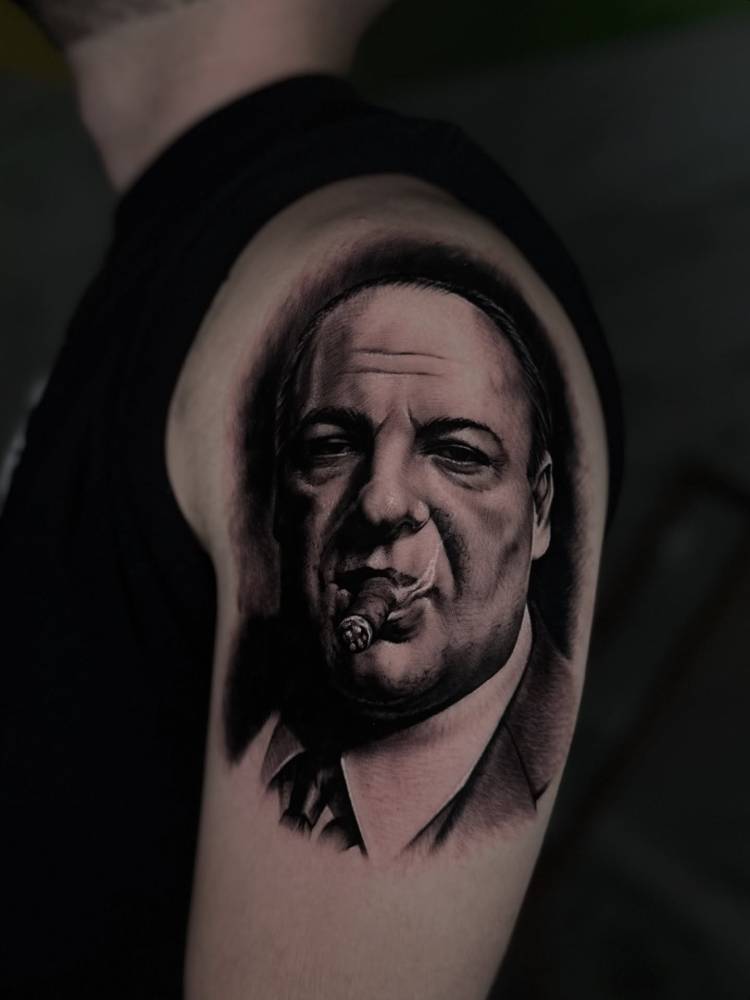 Tony Soprano tattoo in black and grey style placed on the upper arm.