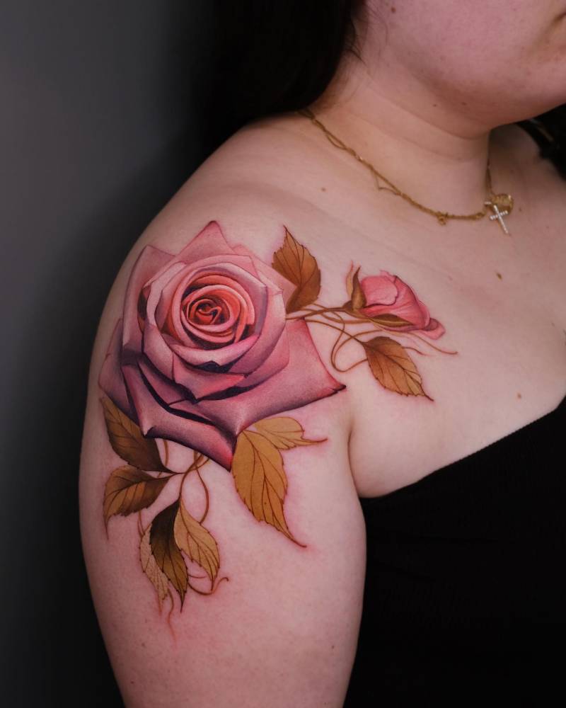 Pink rose head in realism tattooed on the shoulder.