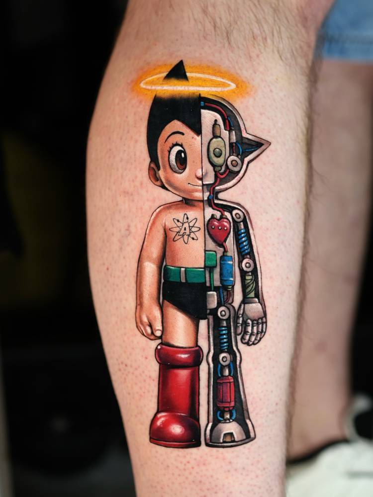 Astro boy aka (Mighty Atom) tattooed on the shin, cartoon style.