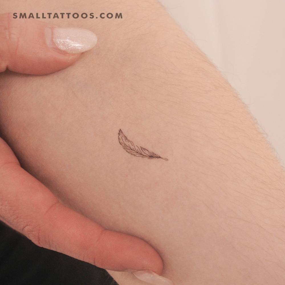 Little fine line style feather temporary tattoo placed on the inner forearm.