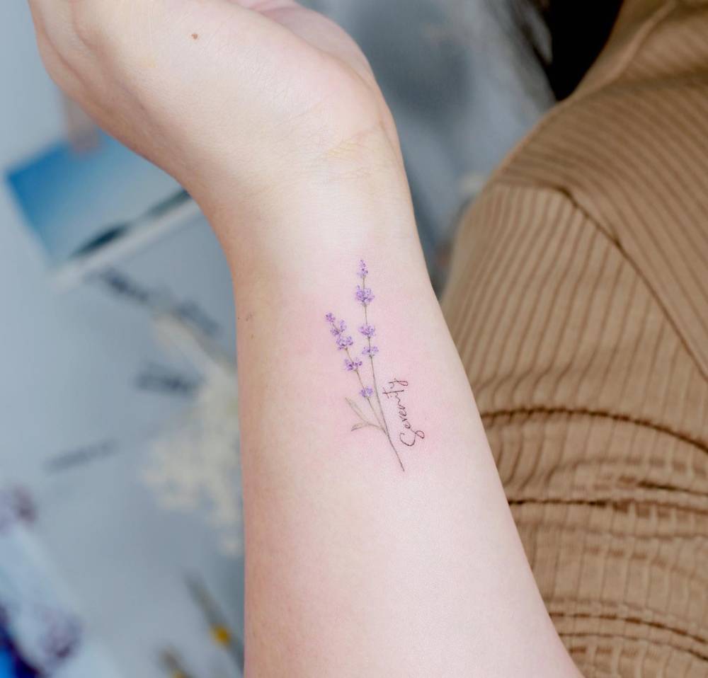 Watercolor style lavender tattoo located on the wrist.