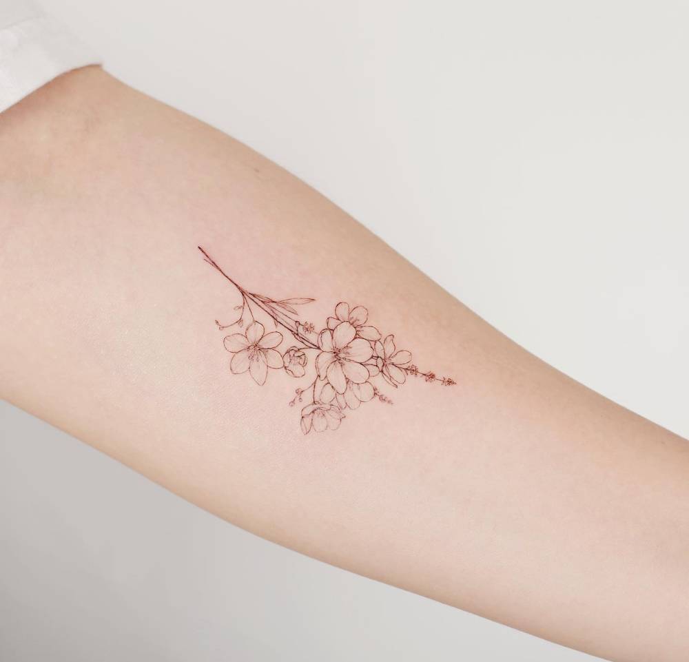 Fine line style flower bouquet tattoo placed on the inner forearm.