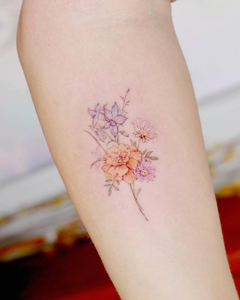 Flower bouquet tattoo in watercolor style located on the inner forearm.