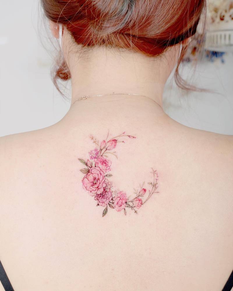 Flower moon tattoo in watercolor style placed on the upper back.
