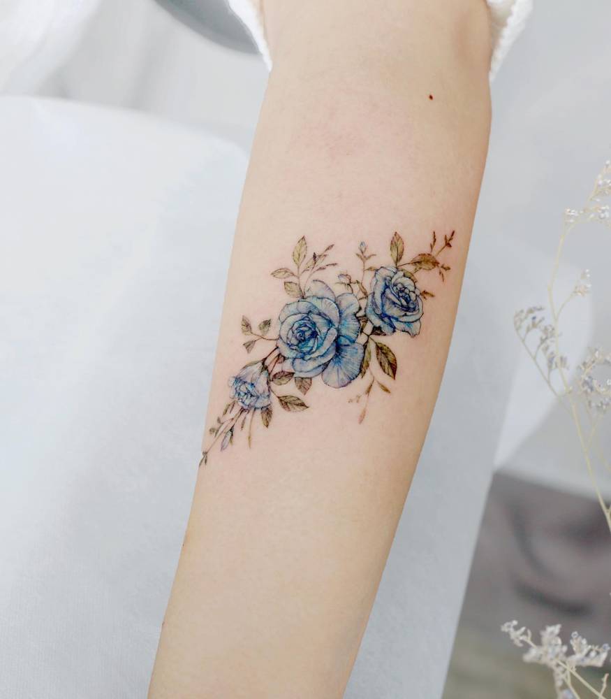 Blue roses tattoo done on the inner forearm, watercolor style.