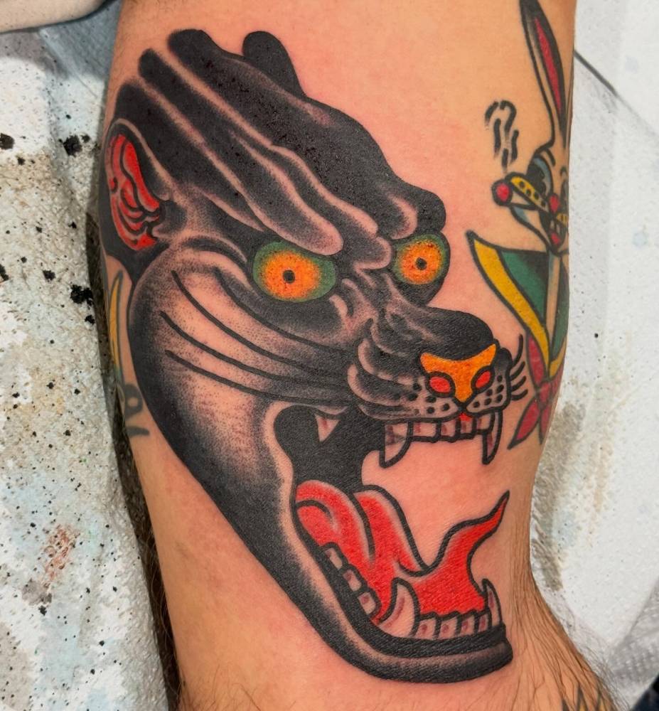 Traditional style black panther tattoo located on the inner arm.