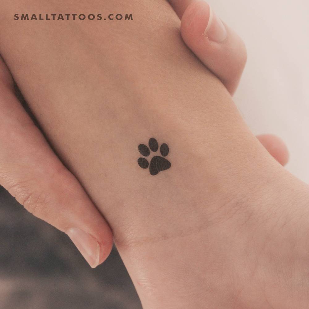 Minimalist style pet paw temporary tattoo located on the wrist.