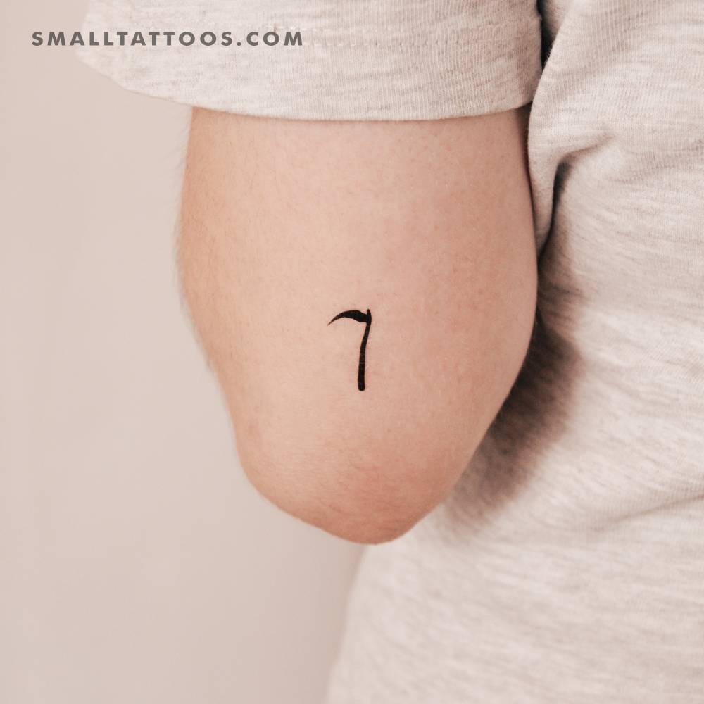 Tiny minimalist scythe temporary tattoo located on the tricep.