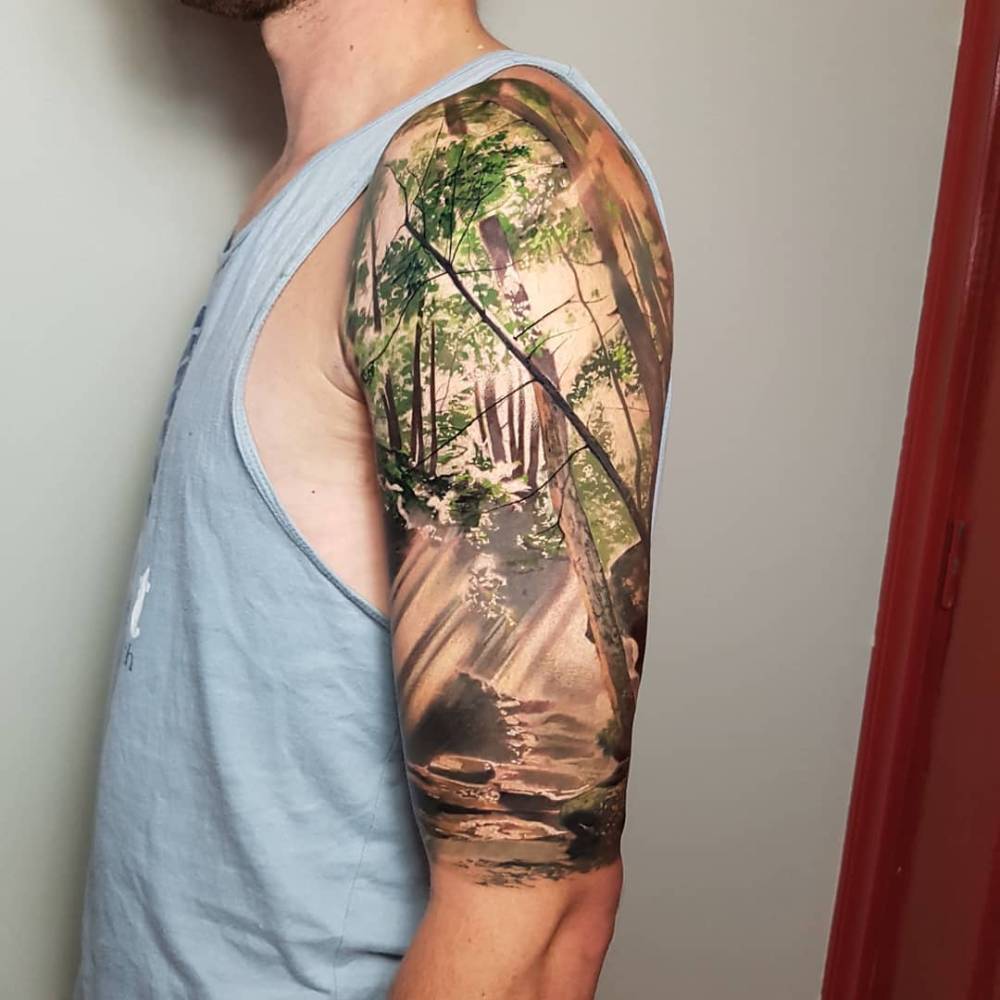 Forest tattoo in realistic style done on the upper arm.