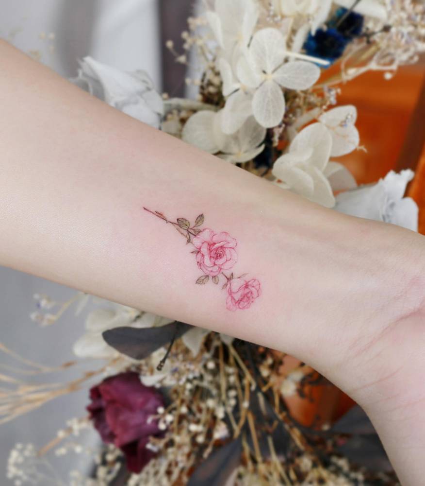 Pink roses tattoo in watercolor style done on the wrist.