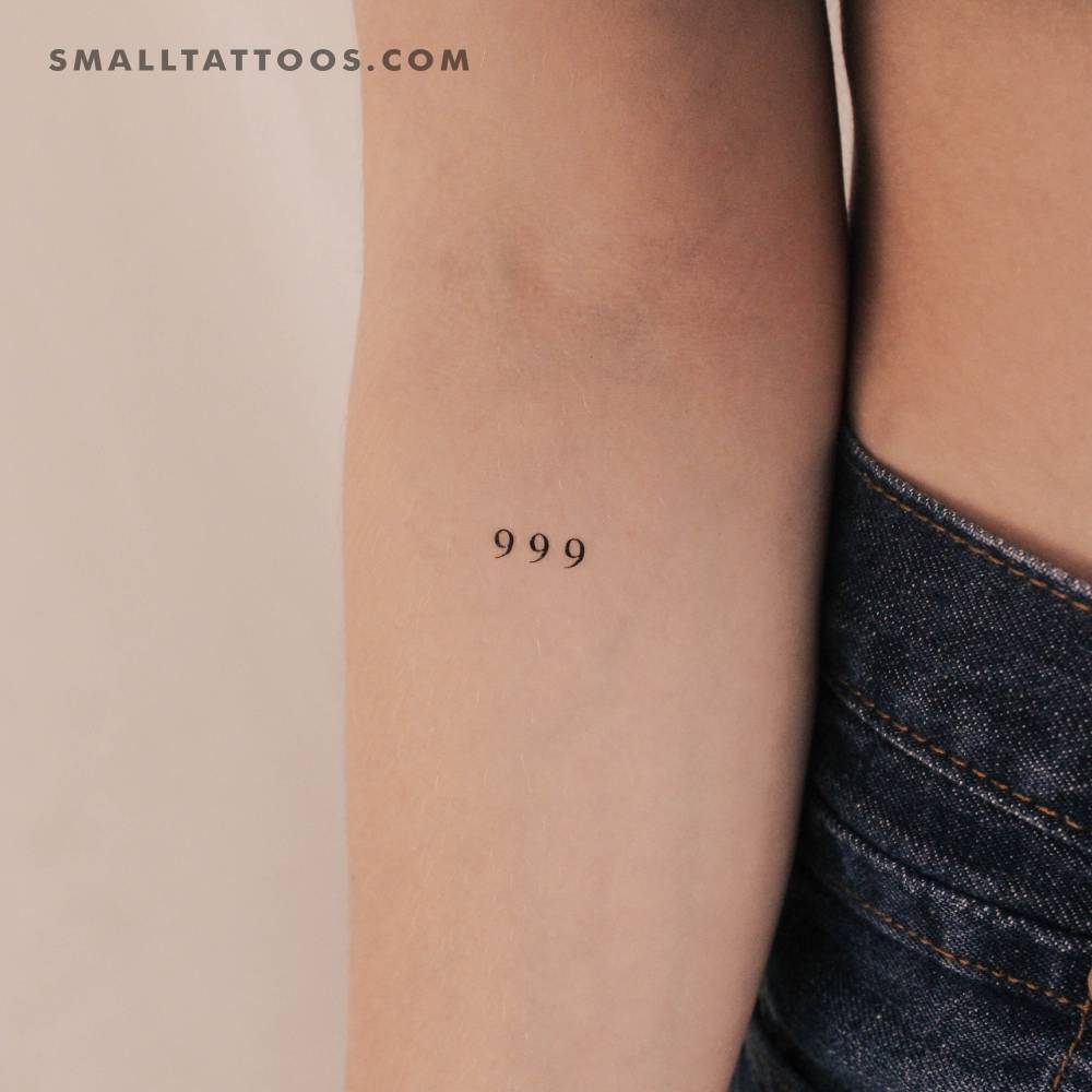 Small "999" angel number temporary tattoo located on the inner forearm.