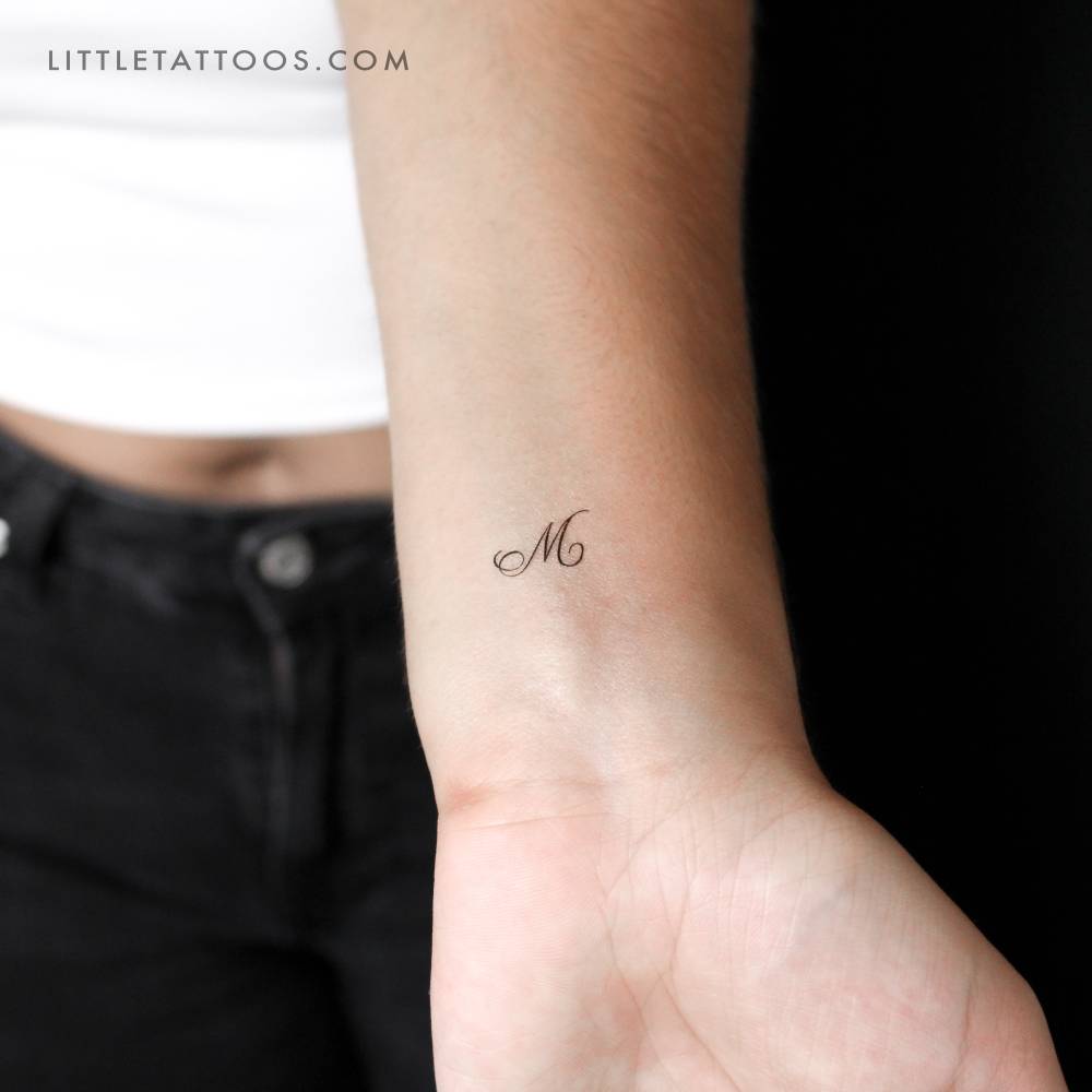 Little letter "M" in script font temporary tattoo.