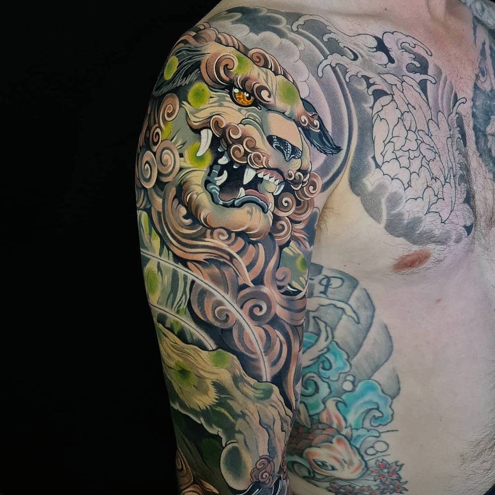 Foo dog half sleeve tattoo in neotraditional style.