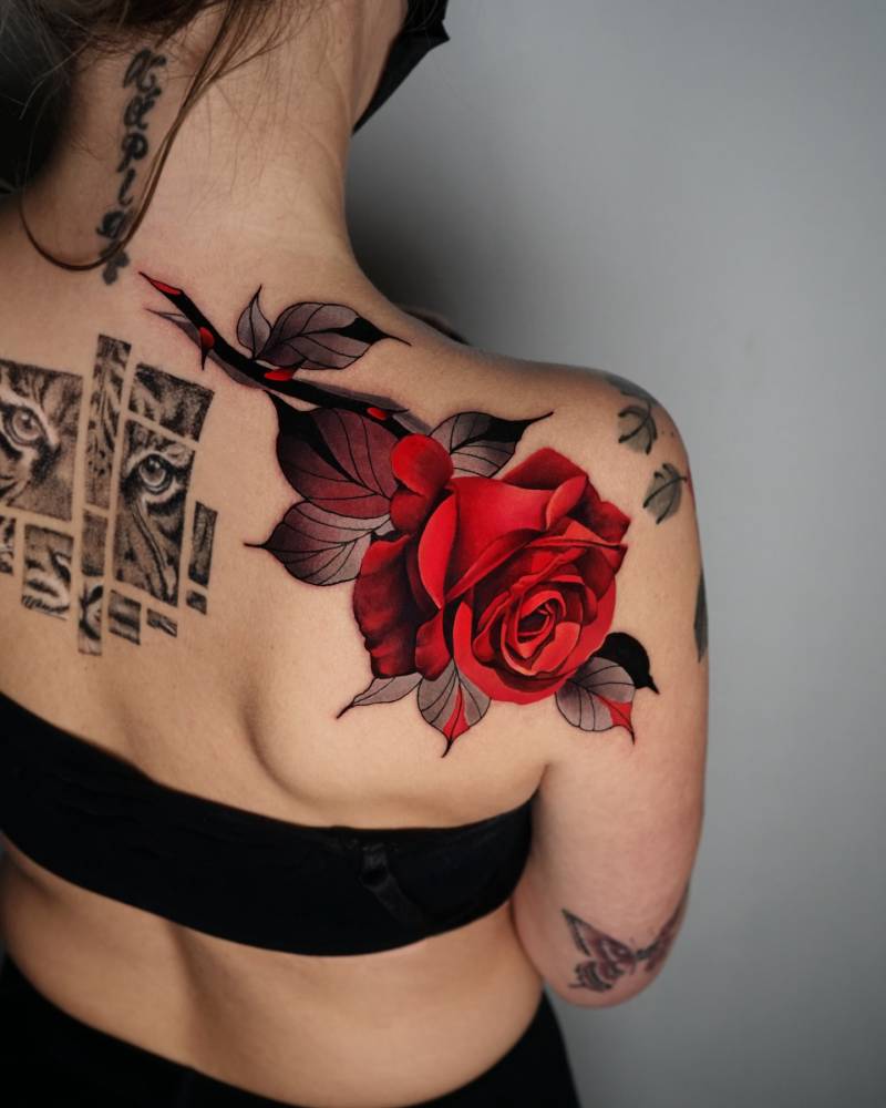 Red rose head tattoo located on the shoulder blade.