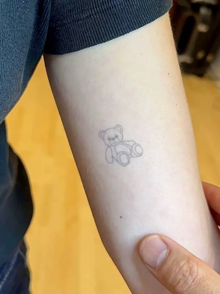 Little teddy bear tattoo in fine line style done on the inner arm (4 years healed).