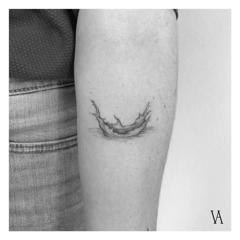 Water splash tattooed on the inner forearm, illustrative style.