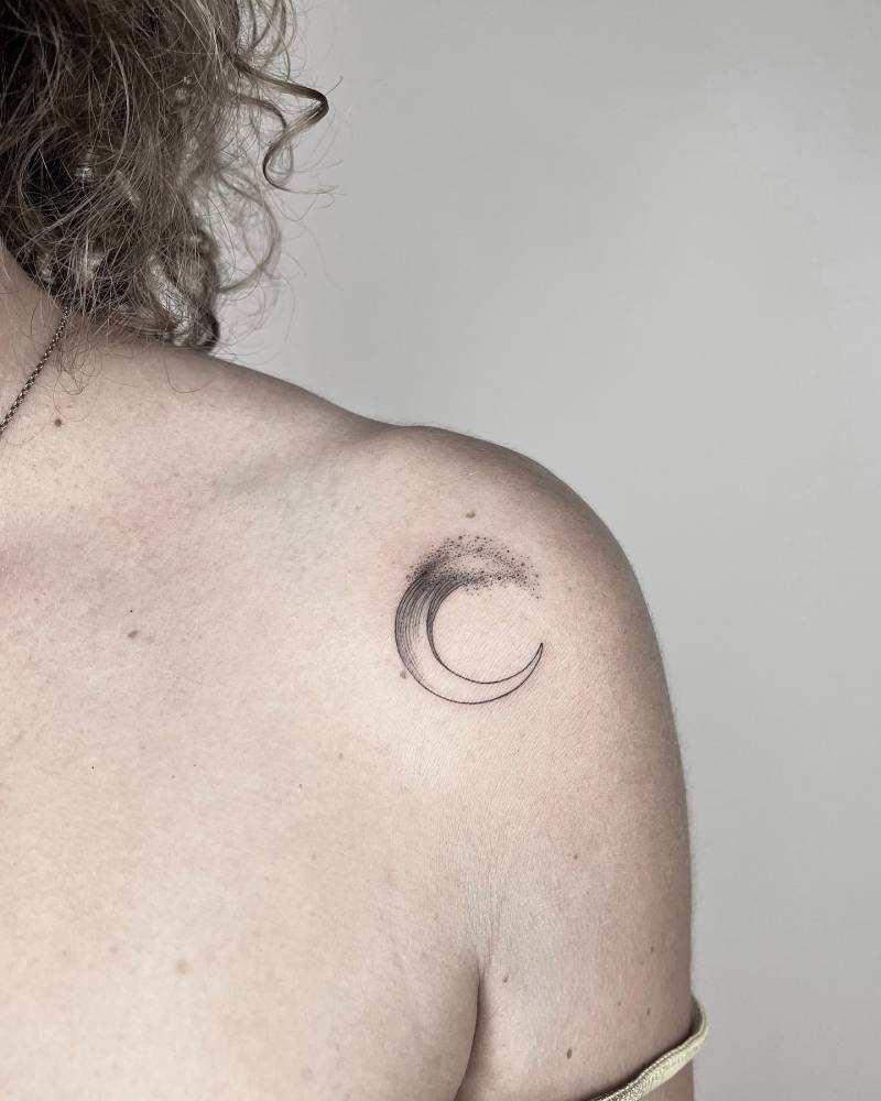 Crescent moon wave tattoo located on the shoulder.
