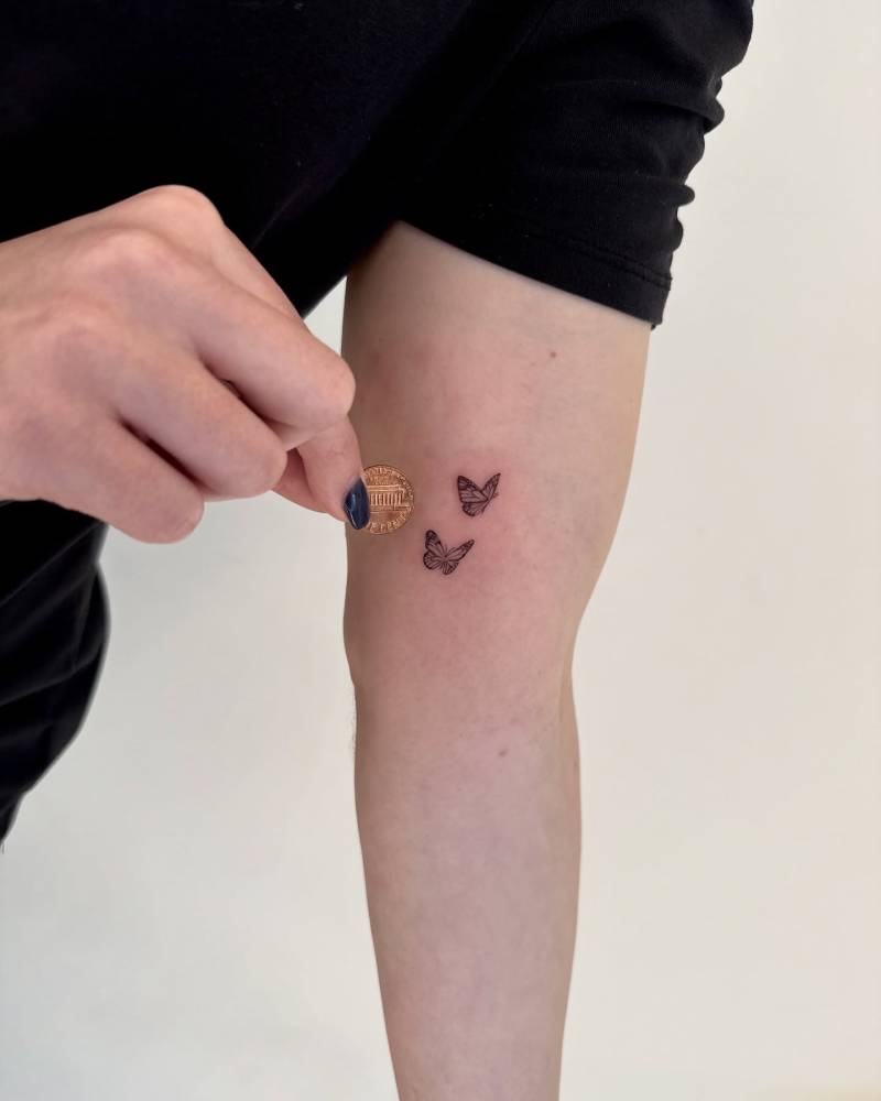 Fine line style tiny butterfly couple tattoo placed on the inner arm.