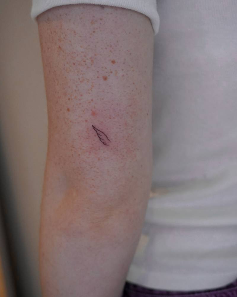Minimalist wing tattoo located on the tricep.