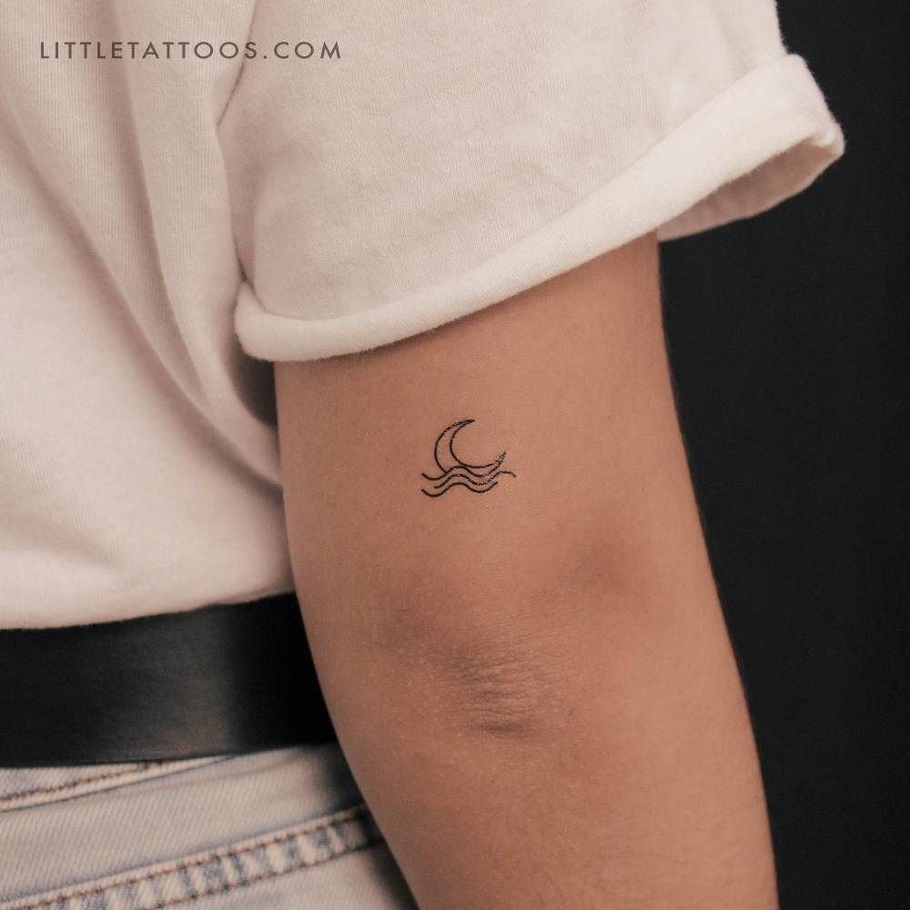Sea moonset temporary tattoo located on the tricep.