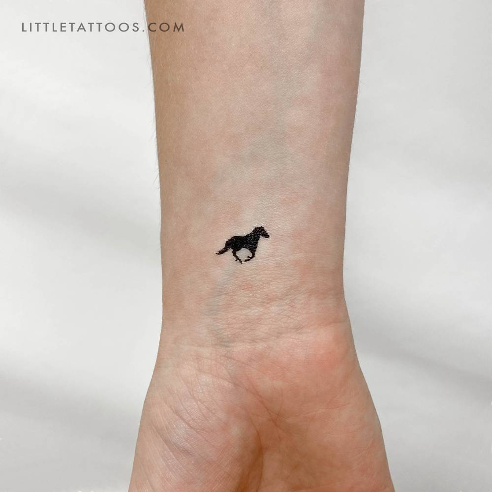 Black horse temporary tattoo located on the wrist, minimalist style.