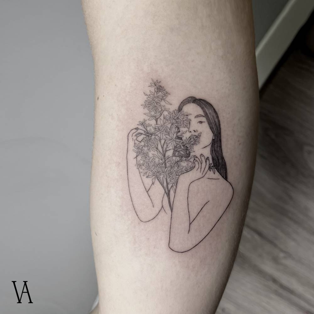 Woman and flower bouquet tattoo located on the inner arm.